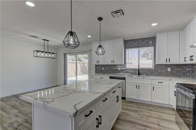 Kitchen featuring a sink, appliances with stainless steel finishes, tasteful backsplash, recessed lighting, and light wood-style floors | Image 11