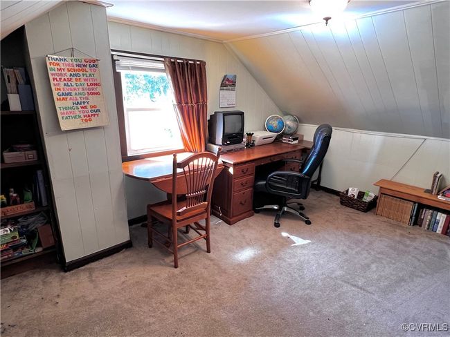Carpeted office featuring lofted ceiling and wooden walls | Image 31
