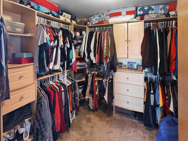Spacious walk-in closet featuring built-in drawers and shelves | Image 29