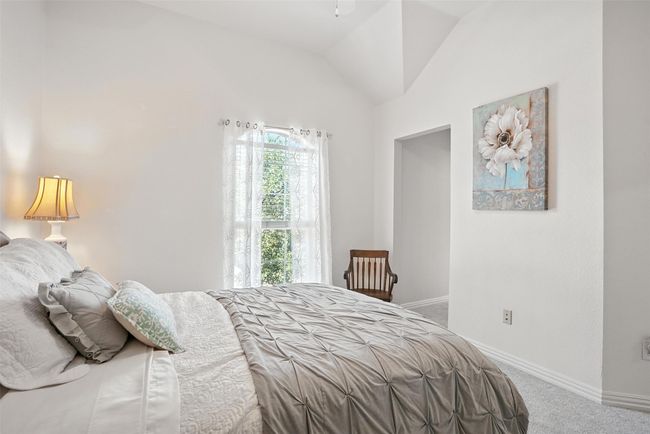 Carpeted bedroom with baseboards and lofted ceiling | Image 24