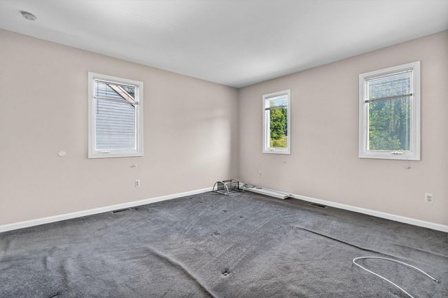 Spare room with dark colored carpet, baseboards, and a smoke detector | Image 22