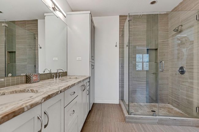 Bathroom with double vanity and a shower stall | Image 13