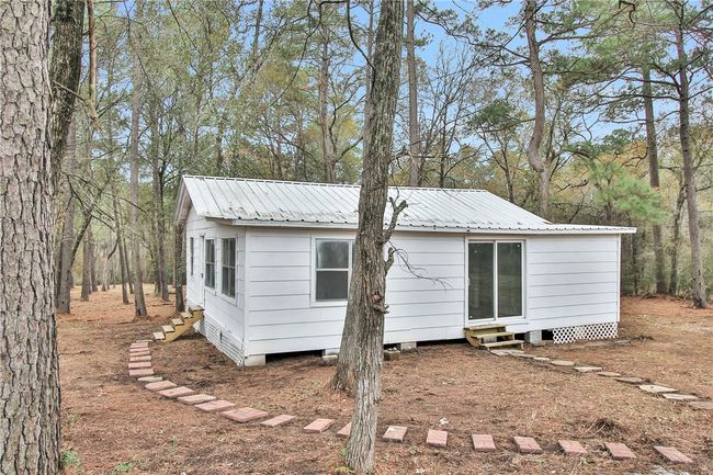 Rear view of house featuring entry steps and a metal roof | Image 17