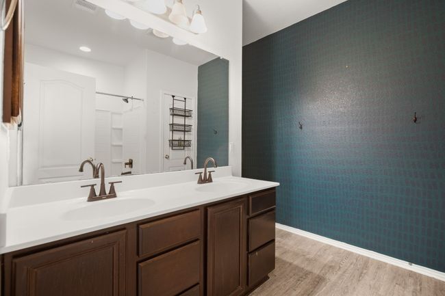 Bathroom featuring double vanity, visible vents, a sink, and wood finished floors | Image 12