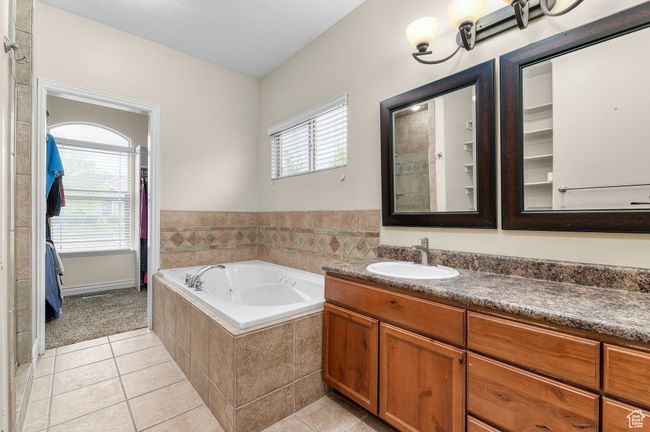Full bathroom featuring tile patterned flooring, a bath, and vanity | Image 9