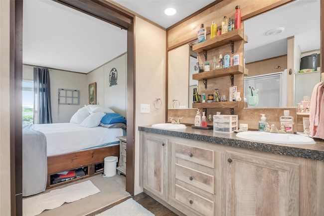 Ensuite bathroom featuring decorative backsplash, double vanity, connected bathroom, and a sink | Image 27