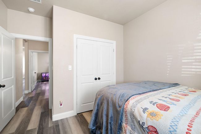 Bedroom with wood finished floors, a closet, and baseboards | Image 23