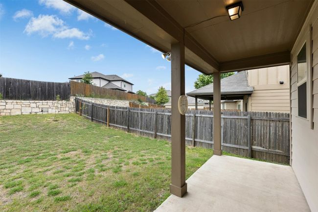 Out back, the covered patio opens to a wide open yard. | Image 19