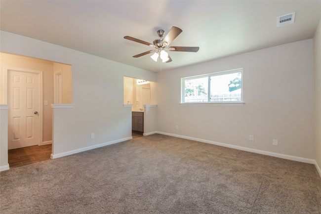 Unfurnished bedroom with carpet floors, ensuite bathroom, and a ceiling fan | Image 16
