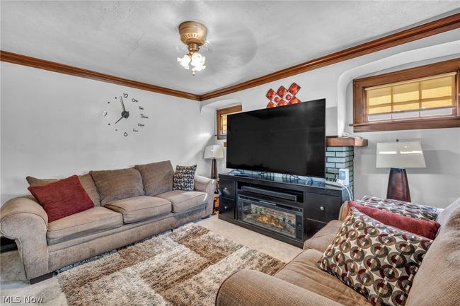 Carpeted living room with crown molding and a wealth of natural light | Image 6