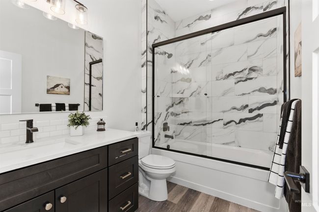 Bathroom with vanity, combined bath / shower with glass door, backsplash, and wood finished floors | Image 30