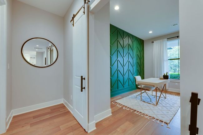 This well appointed office space features dimensional accent wall and can effortlessly serve as a workout room. | Image 19