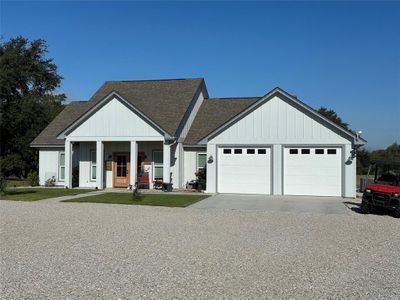 View of front of house with covered porch, a front lawn, and a garage | Image 1