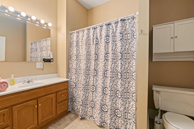 Full bath with vanity, toilet, tile patterned flooring, and curtained shower | Image 14