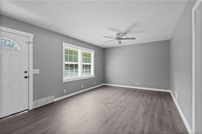 Foyer featuring ceiling fan and light and newly installed vinyl plank flooring | Image 3