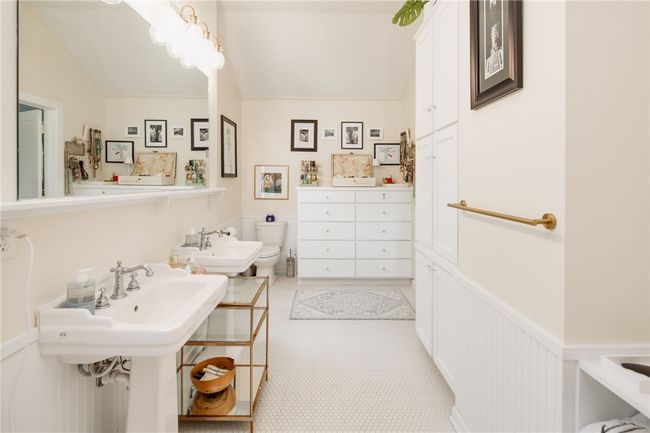 Bathroom featuring toilet, a bidet, vaulted ceiling, and wainscoting | Image 25
