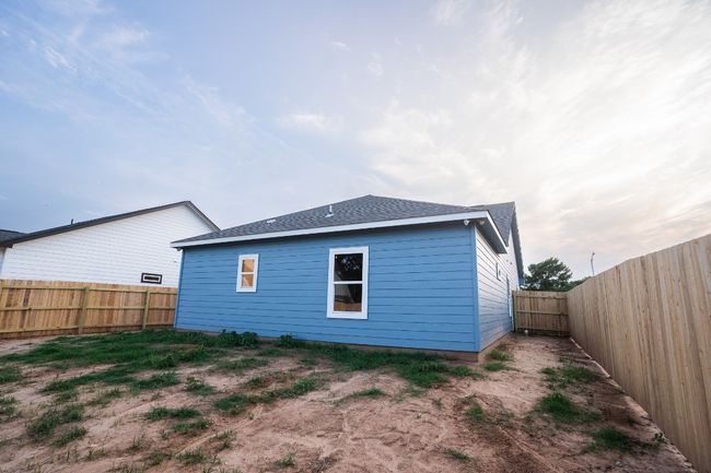 Rear view of house with a fenced backyard and roof with shingles | Image 24