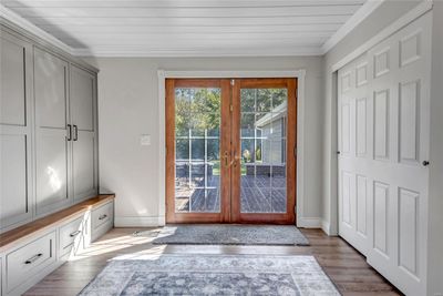 Hearthroom featuring light hardwood / wood-style flooring, french doors, built in desk, and crown molding | Image 2