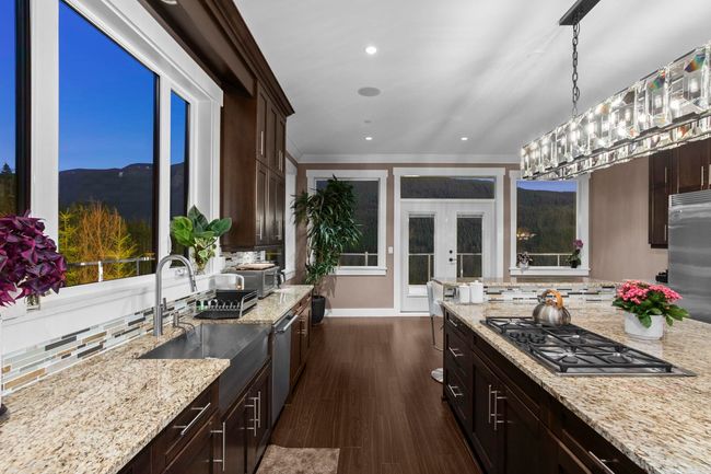 Kitchen with dark wood-style flooring, dark brown cabinetry, french doors, and stainless steel appliances | Image 10