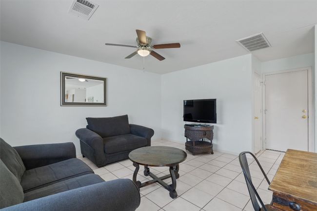 Living room featuring light tile patterned floors, ceiling fan, and visible vents | Image 13