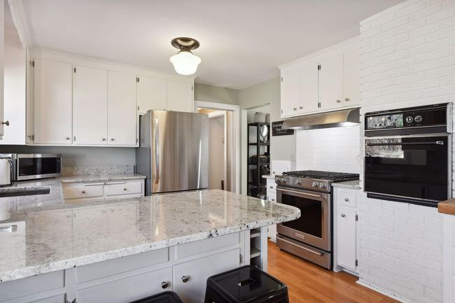 Bright white kitchen with SS appliances, granite countertops | Image 10