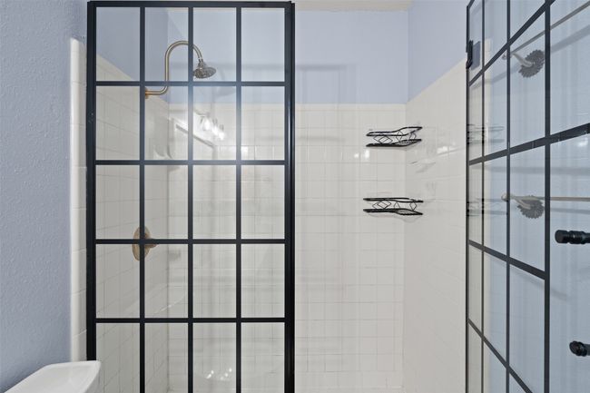 Full bath with a textured wall and tiled shower | Image 23