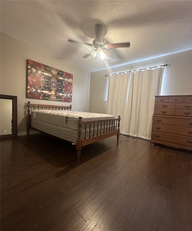 Bedroom featuring dark wood-style floors, a ceiling fan, and baseboards | Image 21