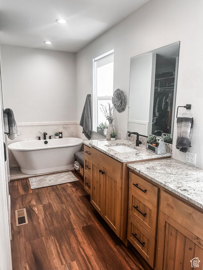 Bathroom featuring visible vents, wood finished floors, recessed lighting, vanity, and a freestanding bath | Image 17