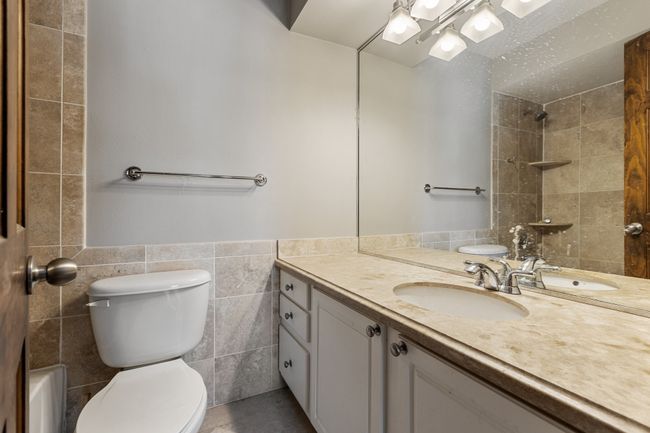 Bathroom with vanity, tile walls, a wainscoted wall, and toilet | Image 20