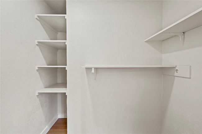 Spacious closet with dark wood-type flooring | Image 11