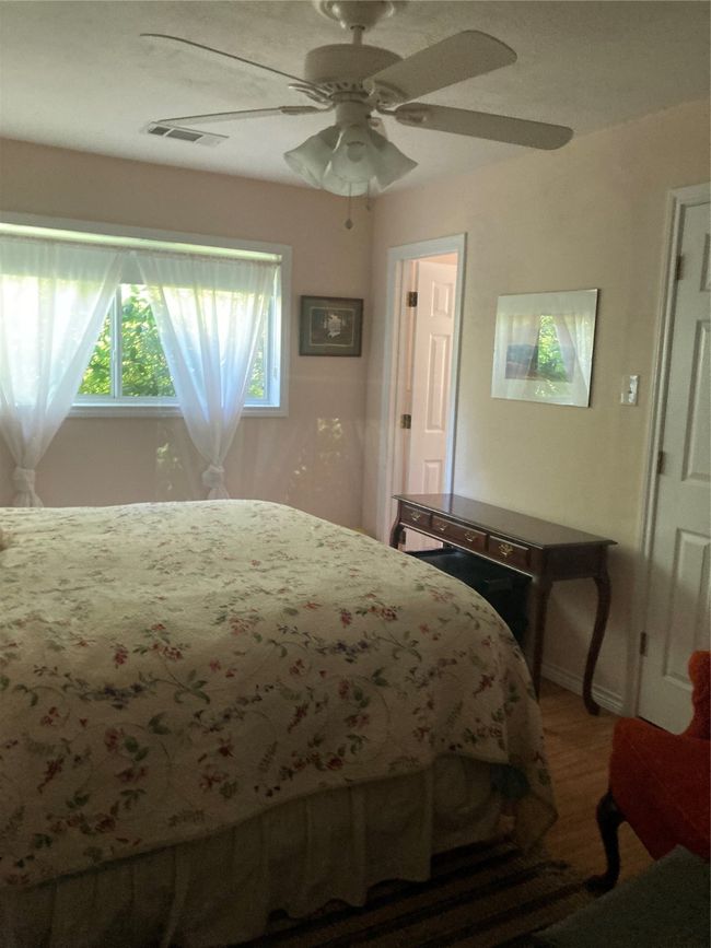 Bedroom featuring a ceiling fan, wood finished floors, and baseboards | Image 26