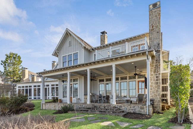 Back of property with a balcony, a chimney, a patio, and board and batten siding | Image 36