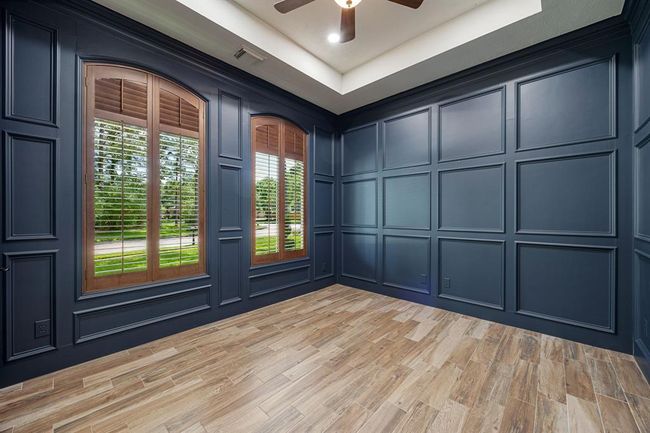 The designated study is at the front of the house and offers custom painted walls and decorative mill work along with a tray ceiling. | Image 17