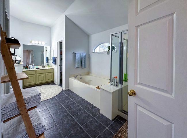 Full bathroom featuring a bath, a shower stall, vanity, and vaulted ceiling | Image 23