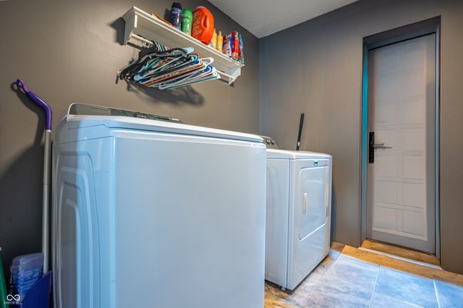 clothes washing area with washing machine and dryer, light tile patterned floors, and laundry area | Image 12