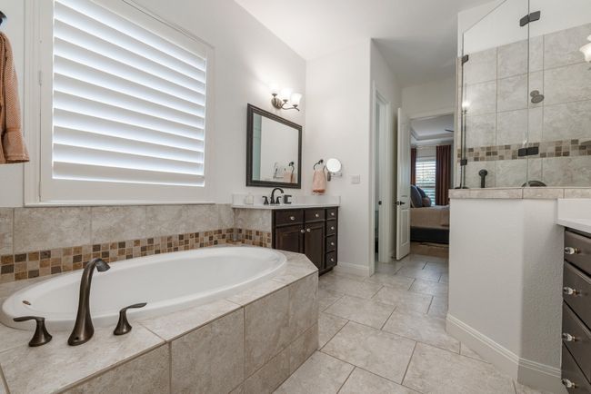 Bathroom with vanity, a garden tub, ensuite bath, tiled shower, and tile patterned flooring | Image 15