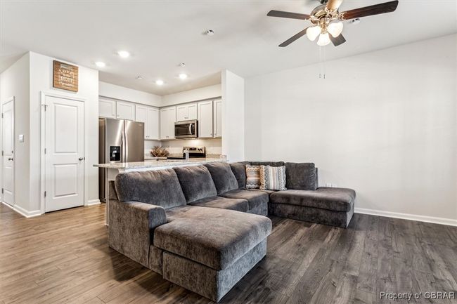 Living area with recessed lighting, wood finished floors, a ceiling fan, and baseboards | Image 11