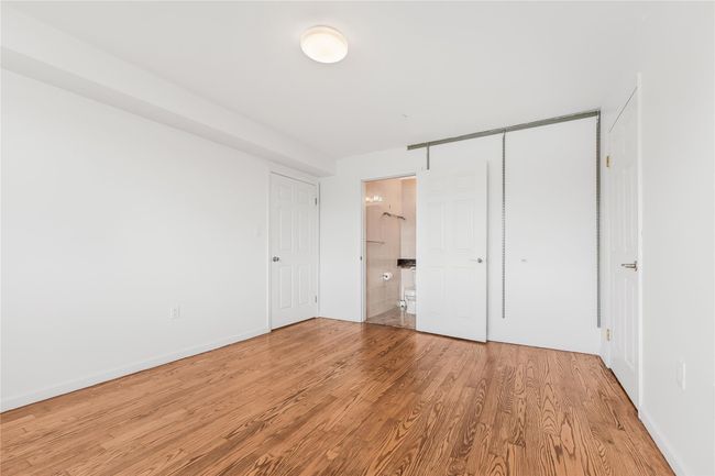 Unfurnished bedroom with wood finished floors and connected bathroom | Image 25