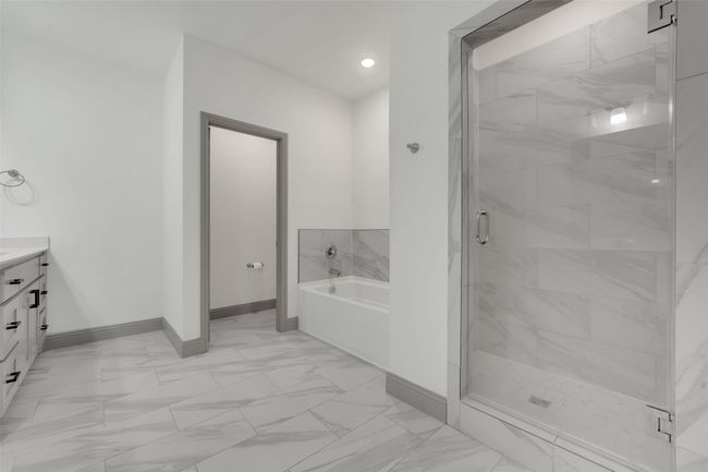 Full bathroom with a bath, vanity, marble finish floor, a stall shower, and baseboards | Image 22