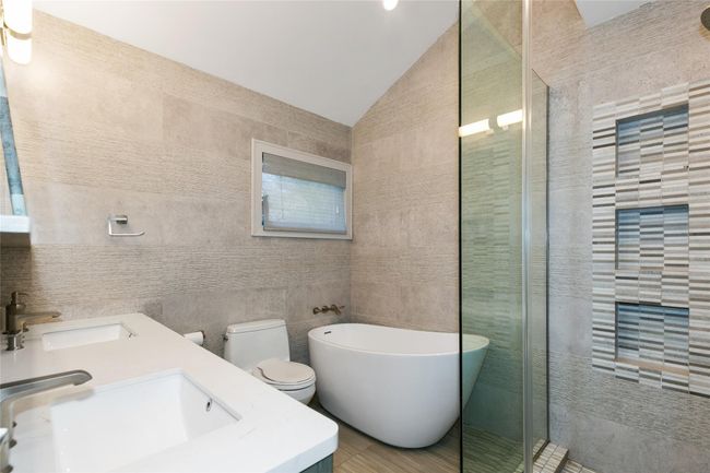 Bathroom with tile walls, a sink, vaulted ceiling, and a soaking tub | Image 13