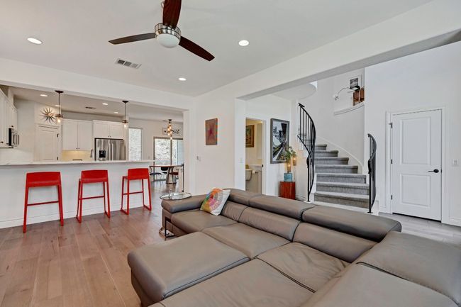 Living room featuring dark wood finished floors, ceiling fan, stairway, and recessed lighting | Image 6