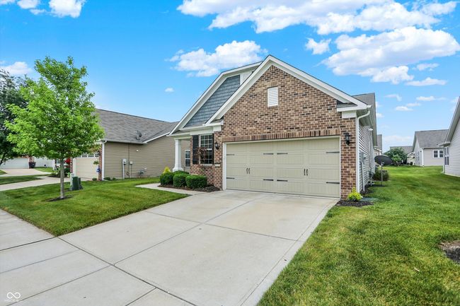 view of front facade featuring brick siding, a front yard, concrete driveway, and an attached garage | Image 20