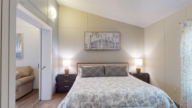 Bedroom featuring light wood finished floors and lofted ceiling | Image 25
