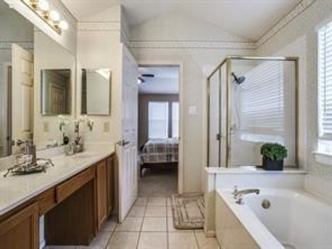 Full bathroom featuring ensuite bathroom, a bath, vanity, a stall shower, and vaulted ceiling | Image 6