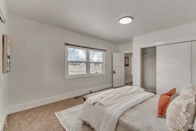 Bedroom with a closet, visible vents, carpet, and baseboards | Image 17