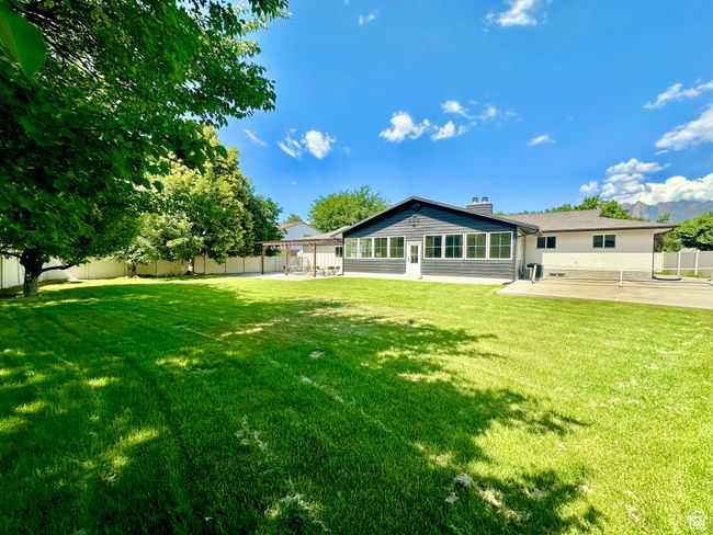 Rear view of property with a patio area, a fenced backyard, a chimney, and a sunroom | Image 42