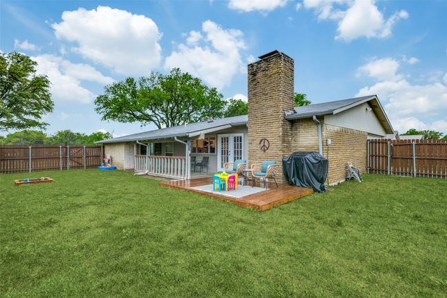 Rear view of property with a yard, french doors, a fenced backyard, and a chimney | Image 24