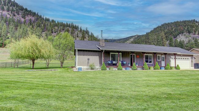 View of front of property featuring covered porch, a garage, a mountain view, and a chimney | Image 58