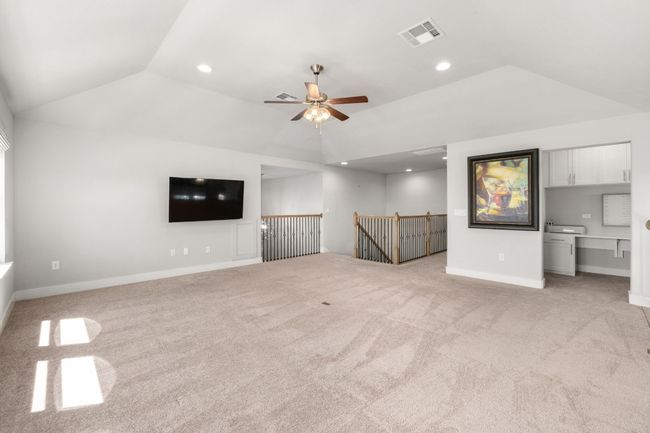 Large game room with vaulted ceiling, ceiling fan, and a healthy amount of sunlight and light carpet | Image 25