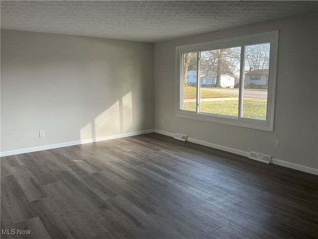 Spare room with dark wood-type flooring and a textured ceiling | Image 11